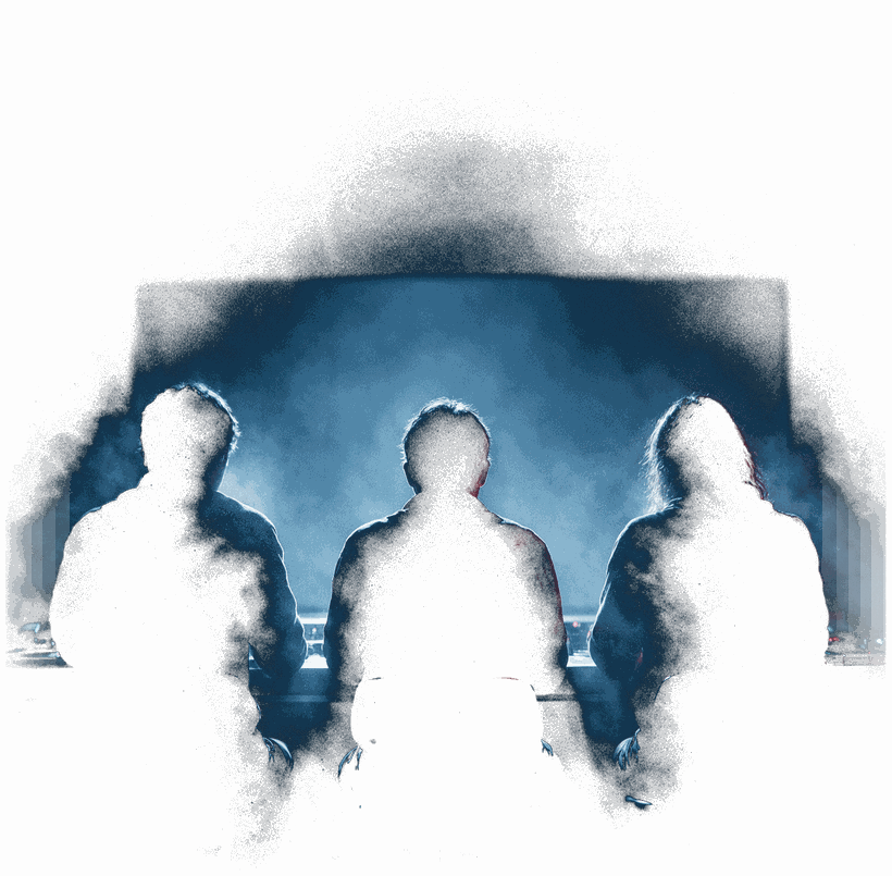 Three operators silhouetted at a shared console